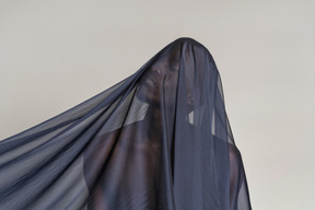 Front view of a young afro man covered with a dark blue shawl