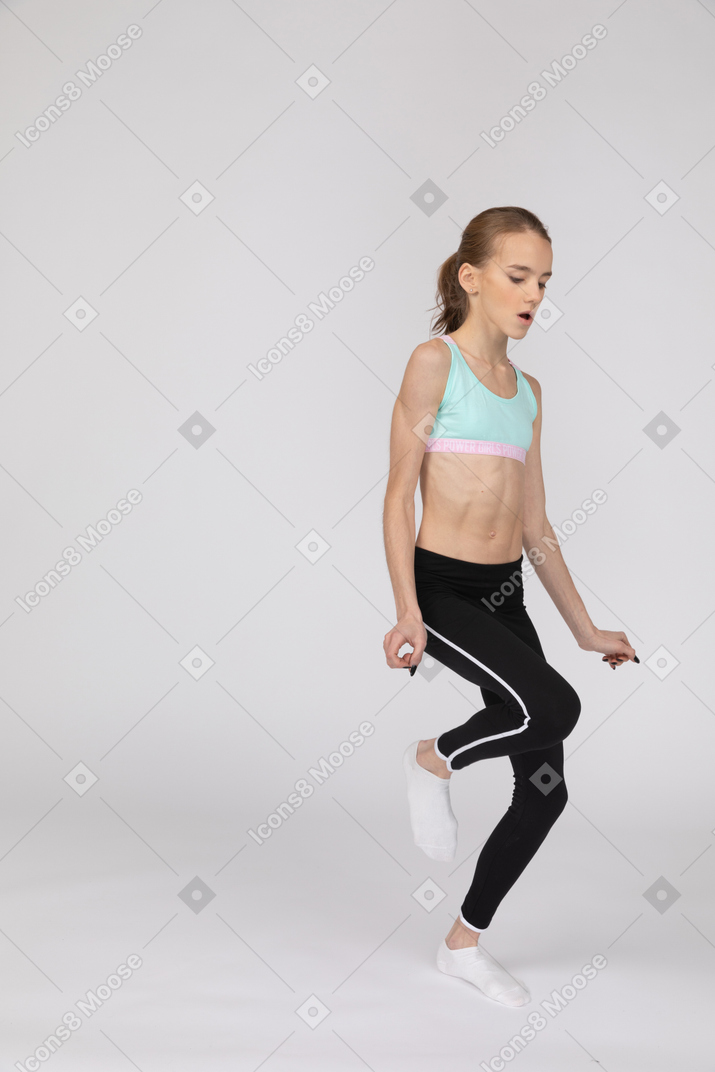 Three-quarter view of a teen girl in sportswear dancing emotionally