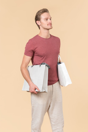 Young guy holding white shopping bags