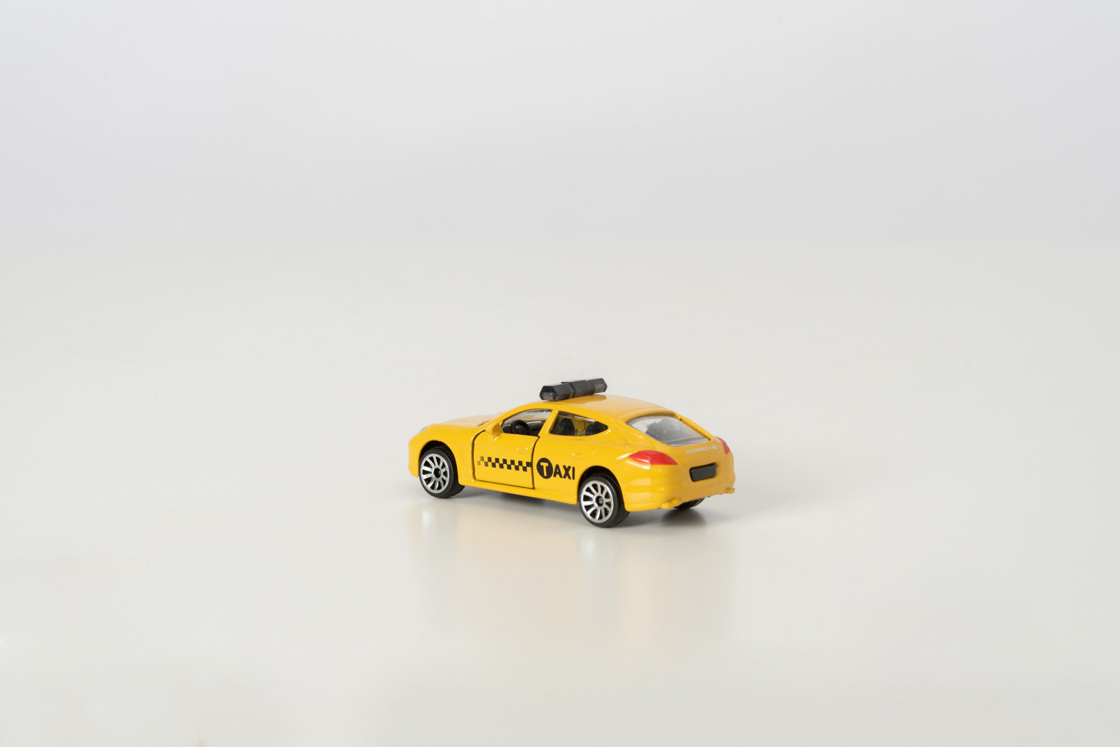 Yellow toy car on grey background