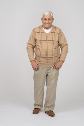 Front view of a happy old man in casual clothes looking at camera