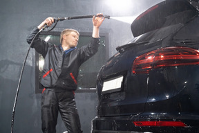 Young man washing car