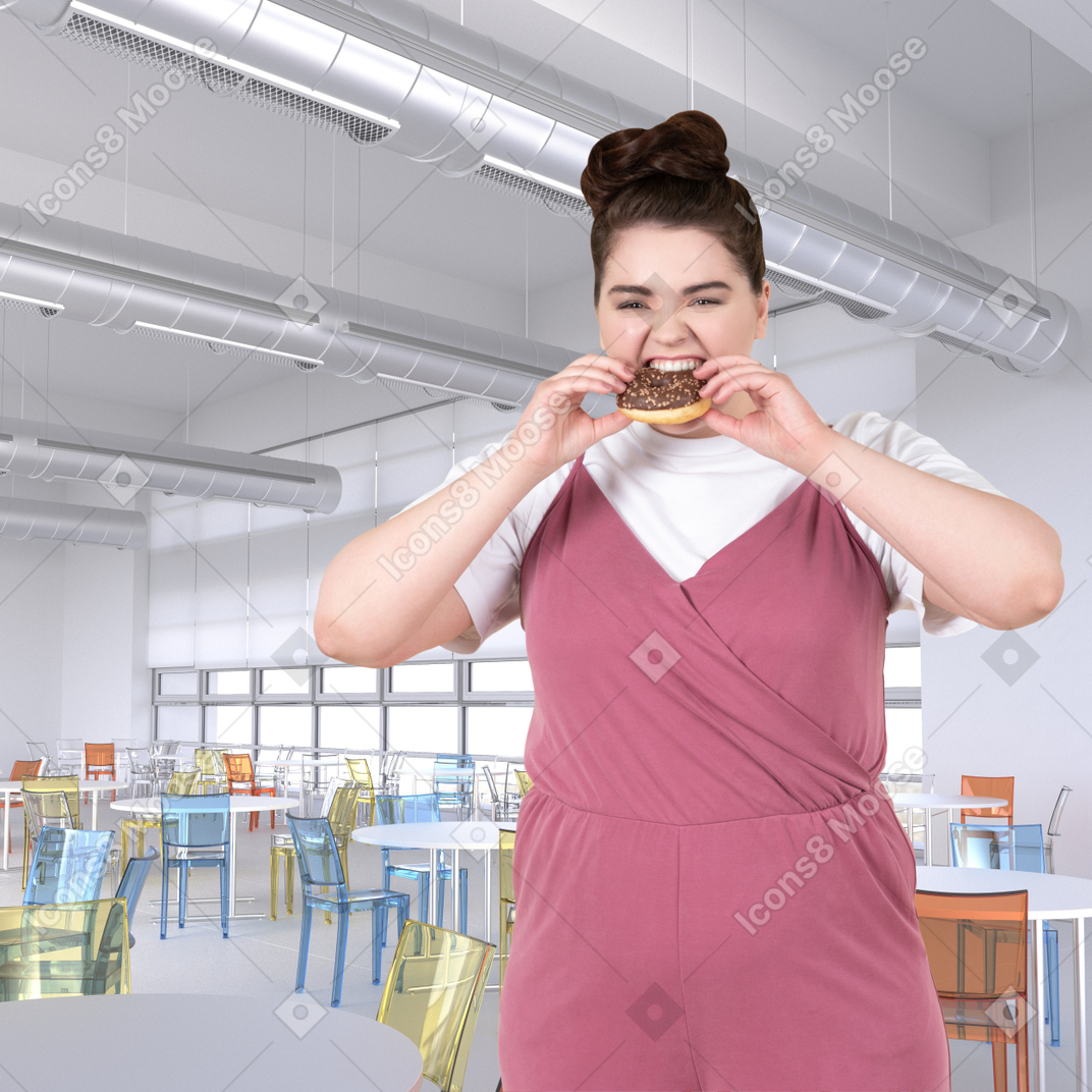チョコレートで覆われたドーナツを食べる女性