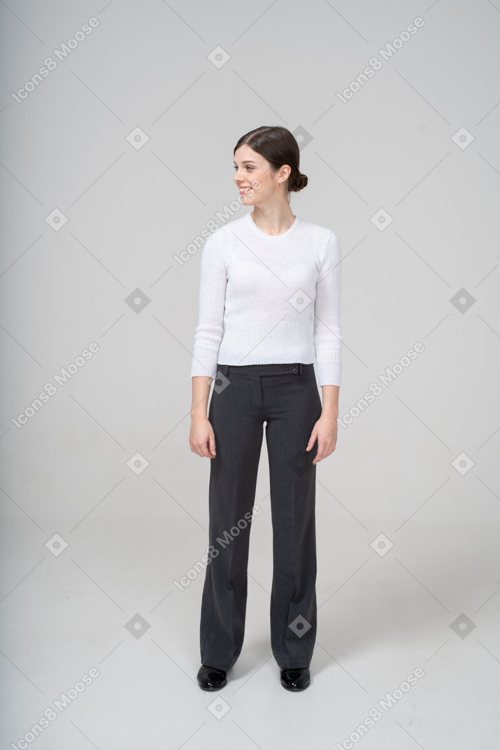 Vue de face d'une femme heureuse en blouse blanche et pantalon noir