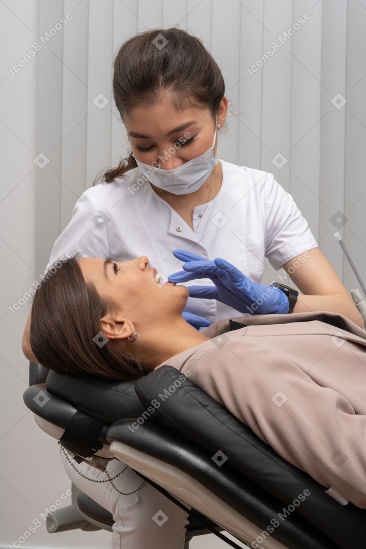 A female dentist taking care of her smiling female patient