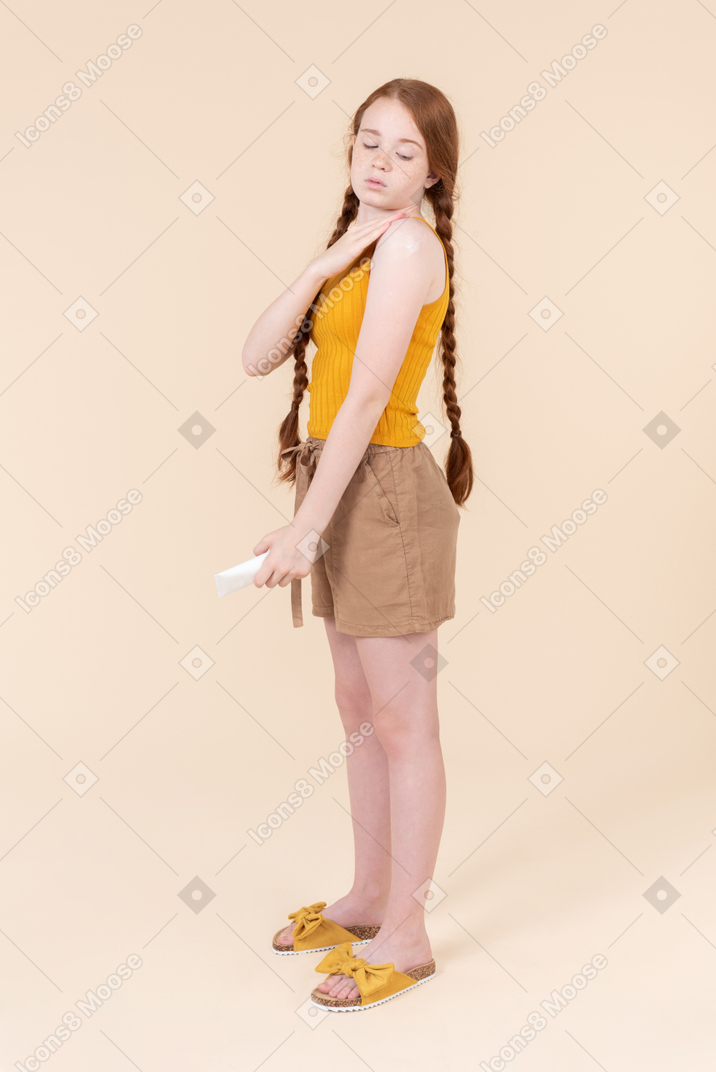 Teenage girl applying sun cream on her hand