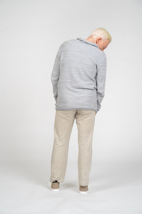 Back view of a man standing and looking down