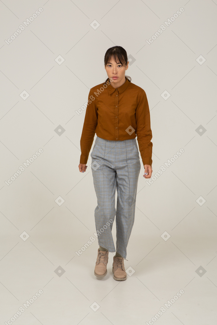 Front view of a stepping young asian female in breeches and blouse