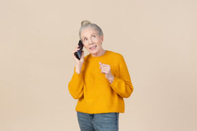 Dreamy old woman talkig on the phone