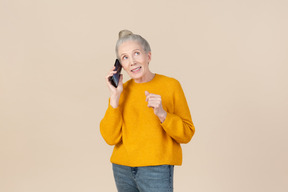 Mujer soñadora hablando por teléfono