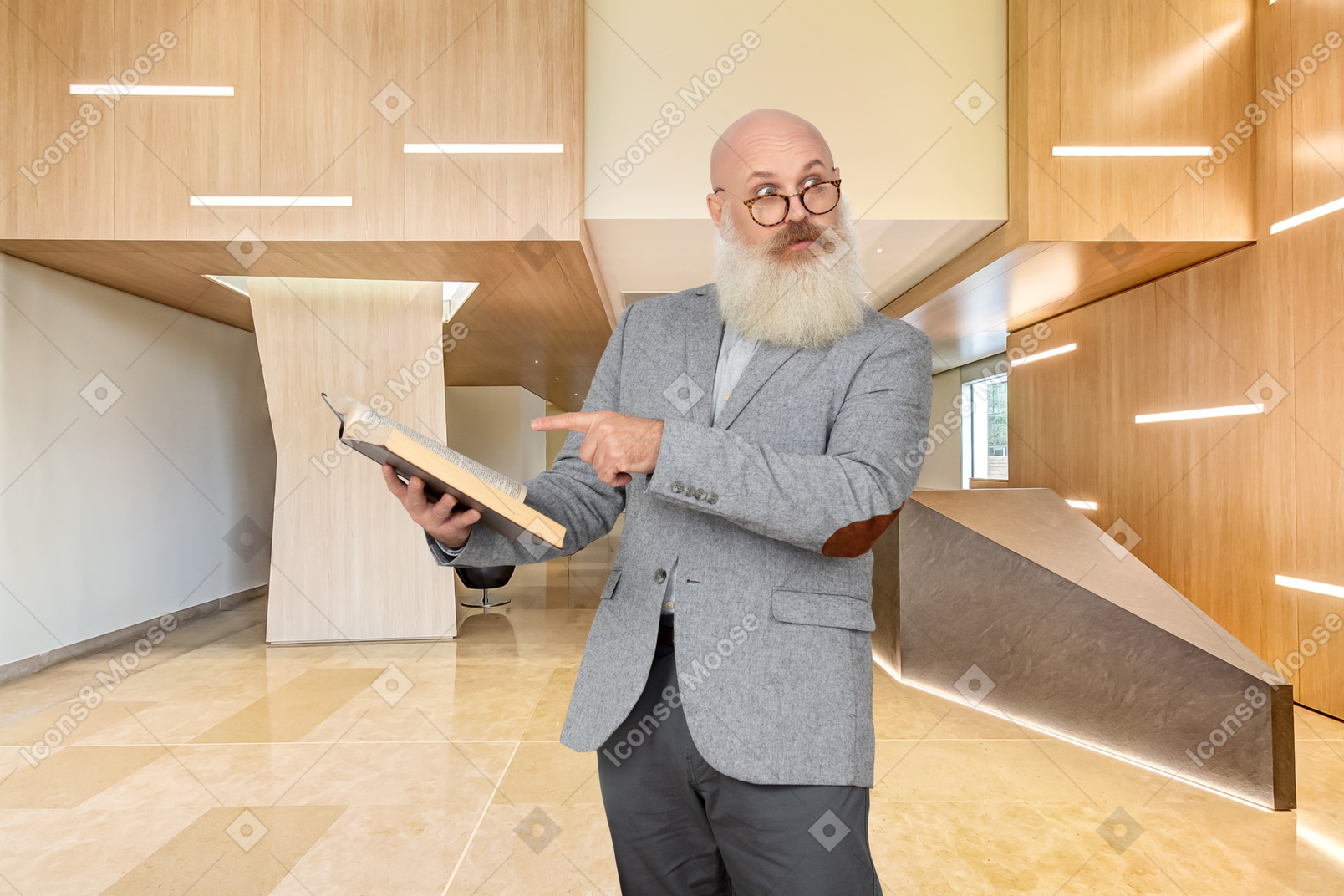A man with a beard and glasses holding a book