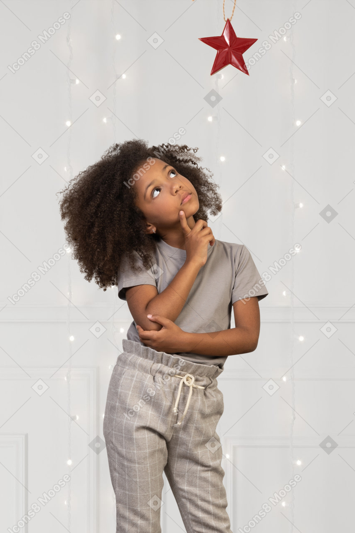 Little girl looking up at a red star