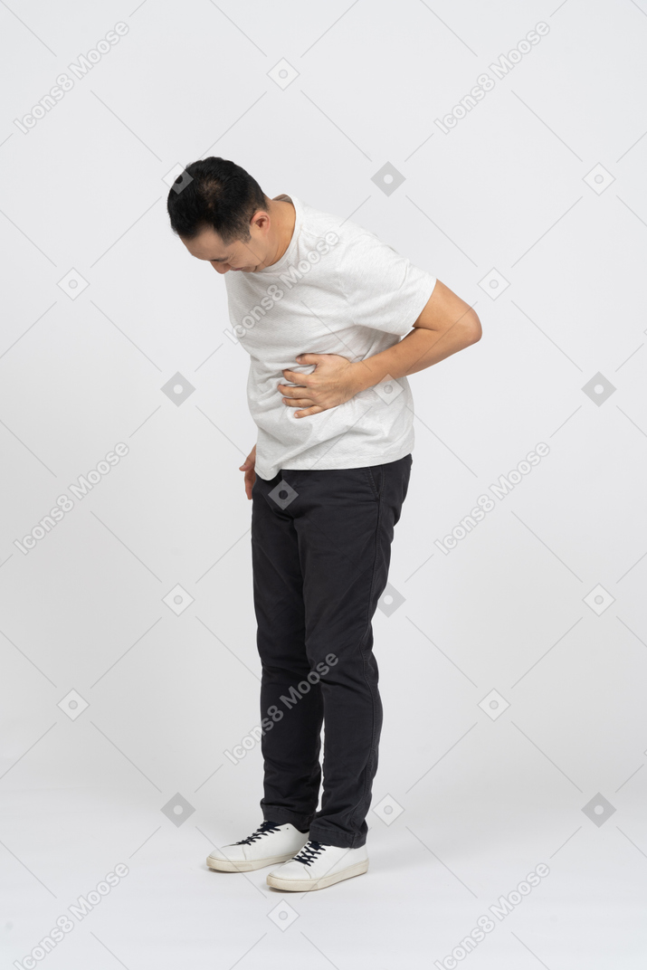 Vista de três quartos de um homem que sofre de dor de estômago