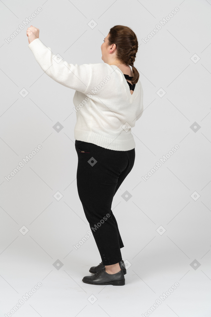 Cheerful plump woman in casual clothes dancing