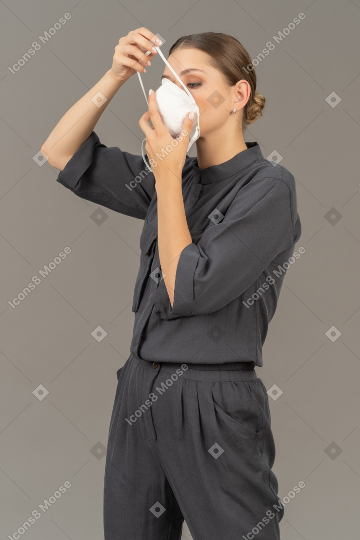 Femme en combinaison grise mettant un respirateur