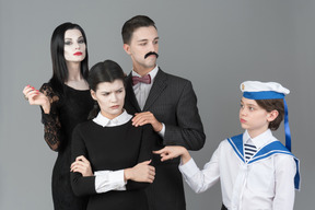 Addams family members and boy in sailor's uniform