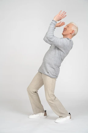 Side view of a man with bent knees raising arms and smiling