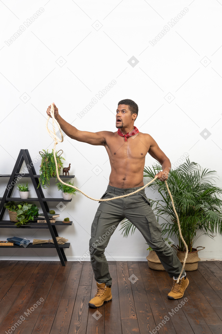 Athletic man holding a long rope