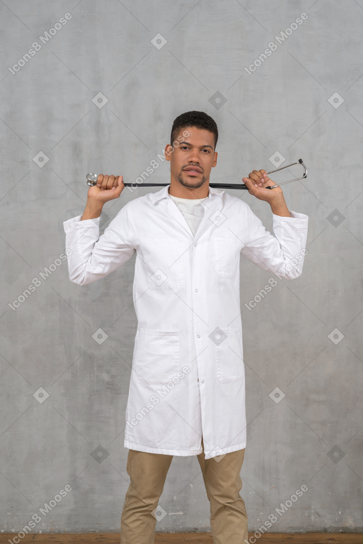 Männlicher arzt, der ein stethoskop hält