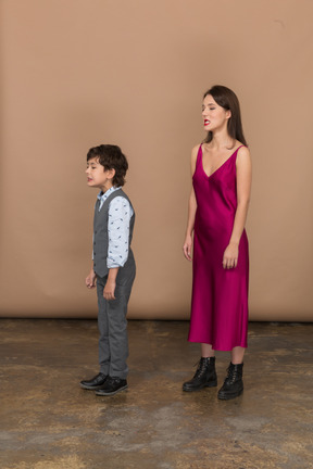 Side view of a young woman in red dress and boy