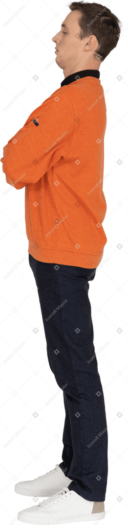 Young man in orange sweatshirt standing