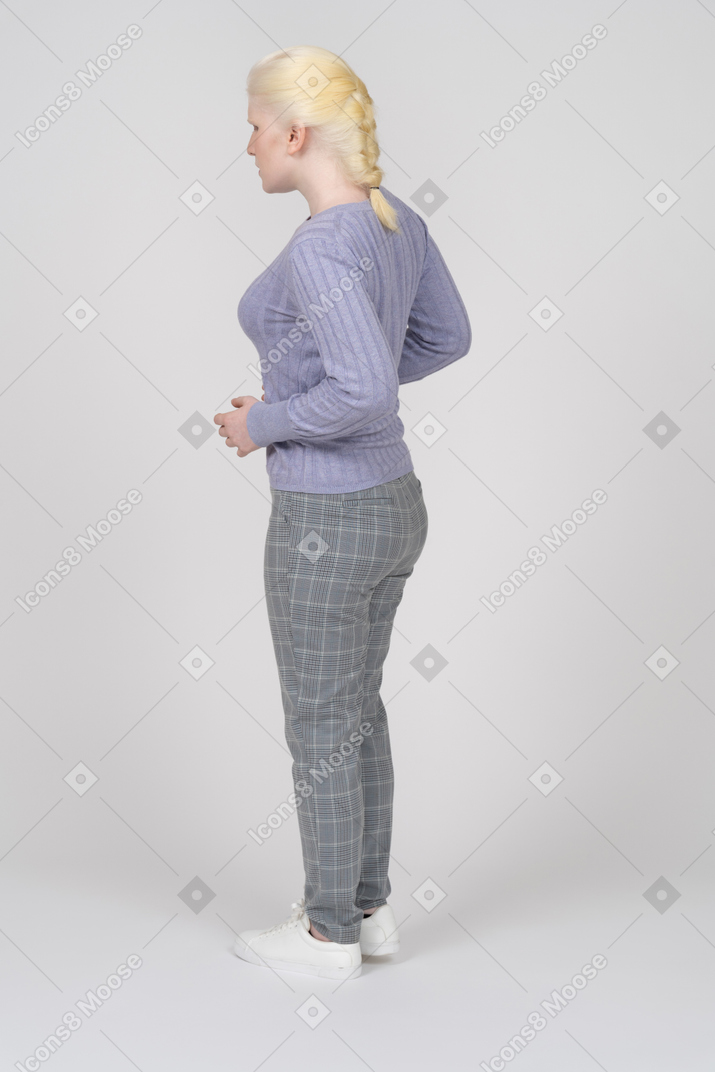 Rear view of young woman standing and bending arms