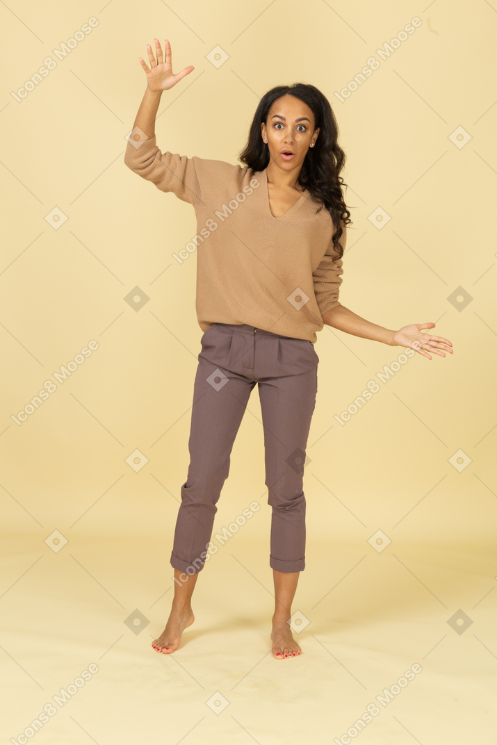 Vista frontal de una mujer joven de piel oscura extendiendo sus manos