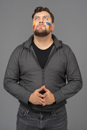 Front view of a male football fan with colorful face art