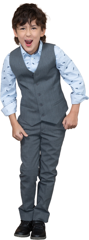Vista frontale di un ragazzo felice in abito grigio che guarda l'obbiettivo