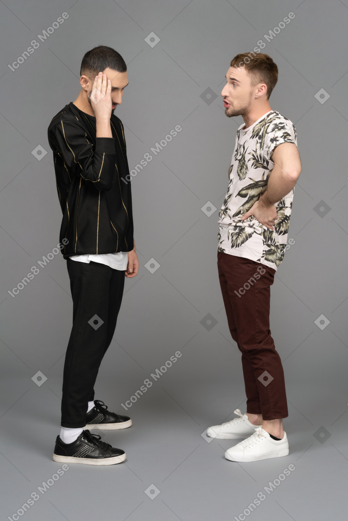 Side view of two young men arguing