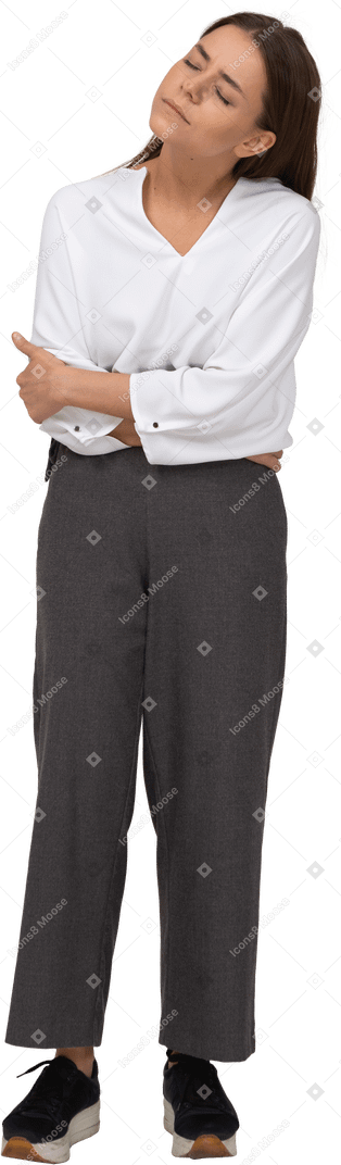 Front view of a young lady in office clothing with stomach ache bending down