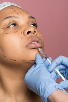 Femme afro-américaine recevant une injection d'acide hyaluronique