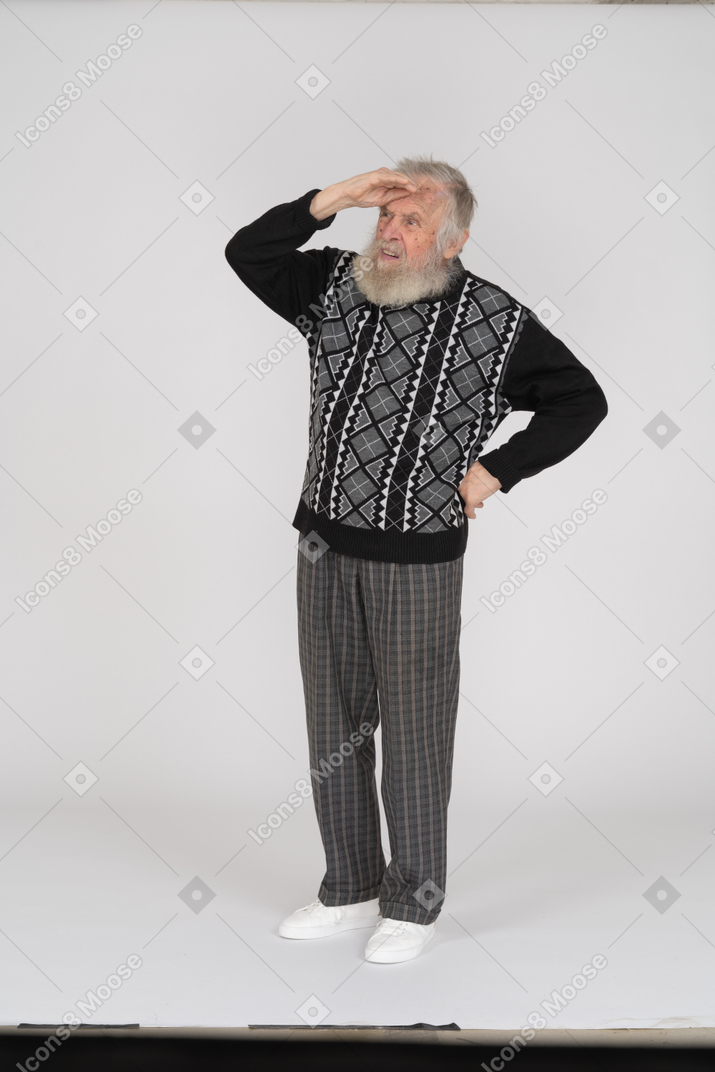Old man with hand on forehead looking into distance