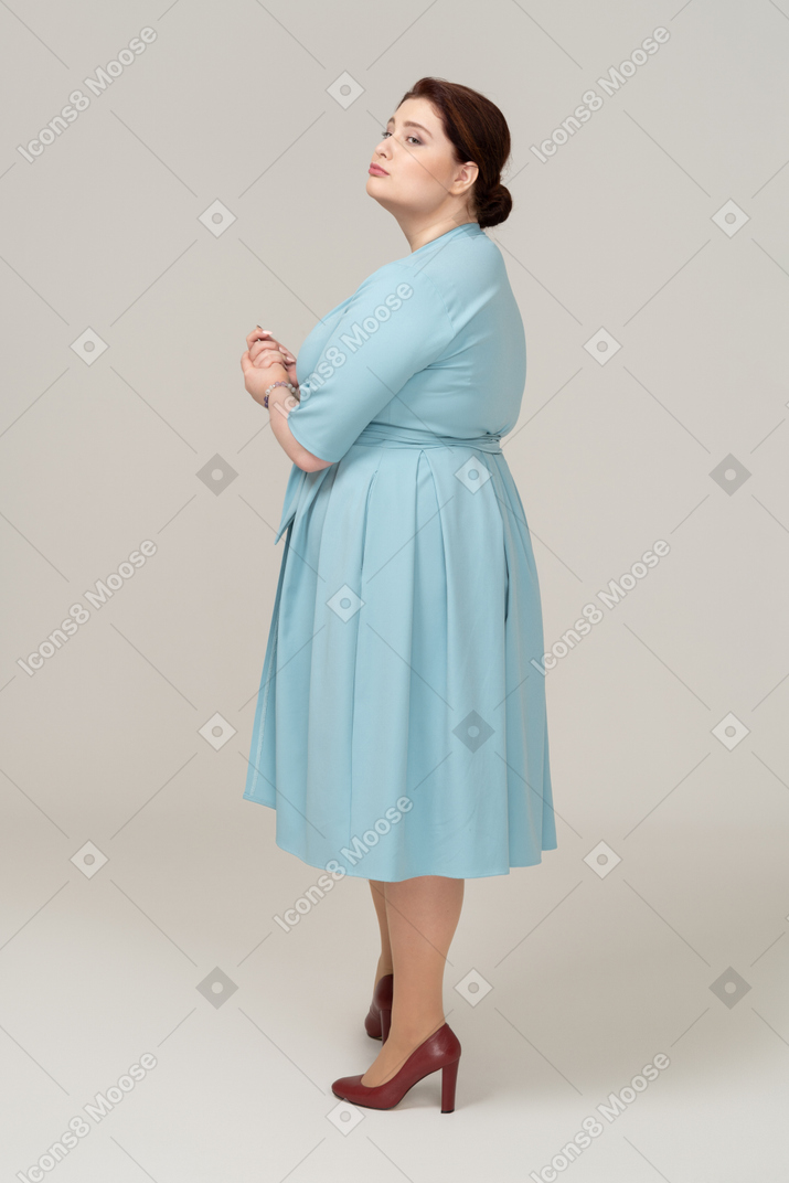 Side view of a woman in blue dress posing