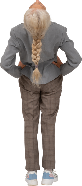 Rear view of an old lady in suit bending back