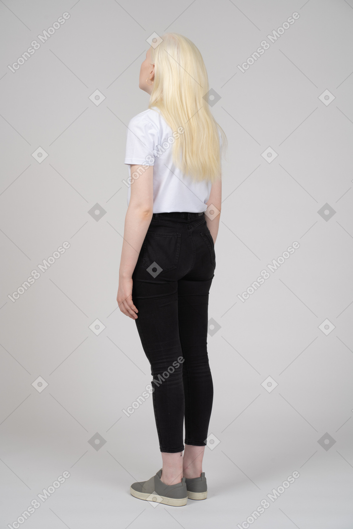 Vista posteriore di tre quarti di una ragazza adolescente con le braccia ai lati
