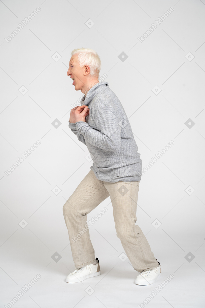 Man standing sideways with hands on hist chest and screaming