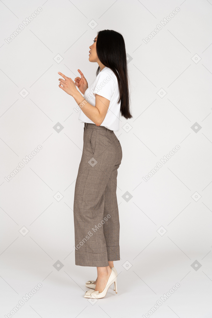 Side view of a gesticulating arguing young lady in breeches and t-shirt