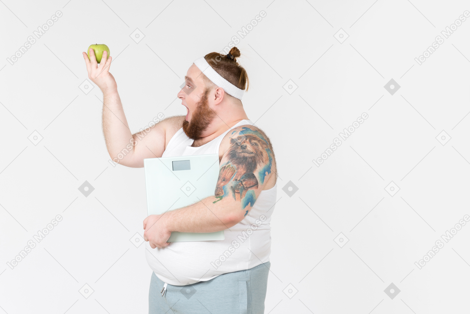 Excited young man holding scales and looking at green apple