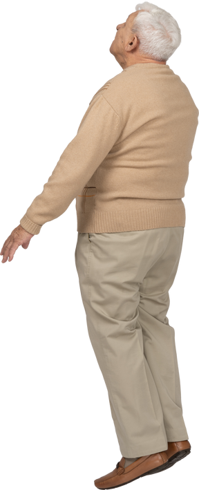Side view of an old man in casual clothes jumping