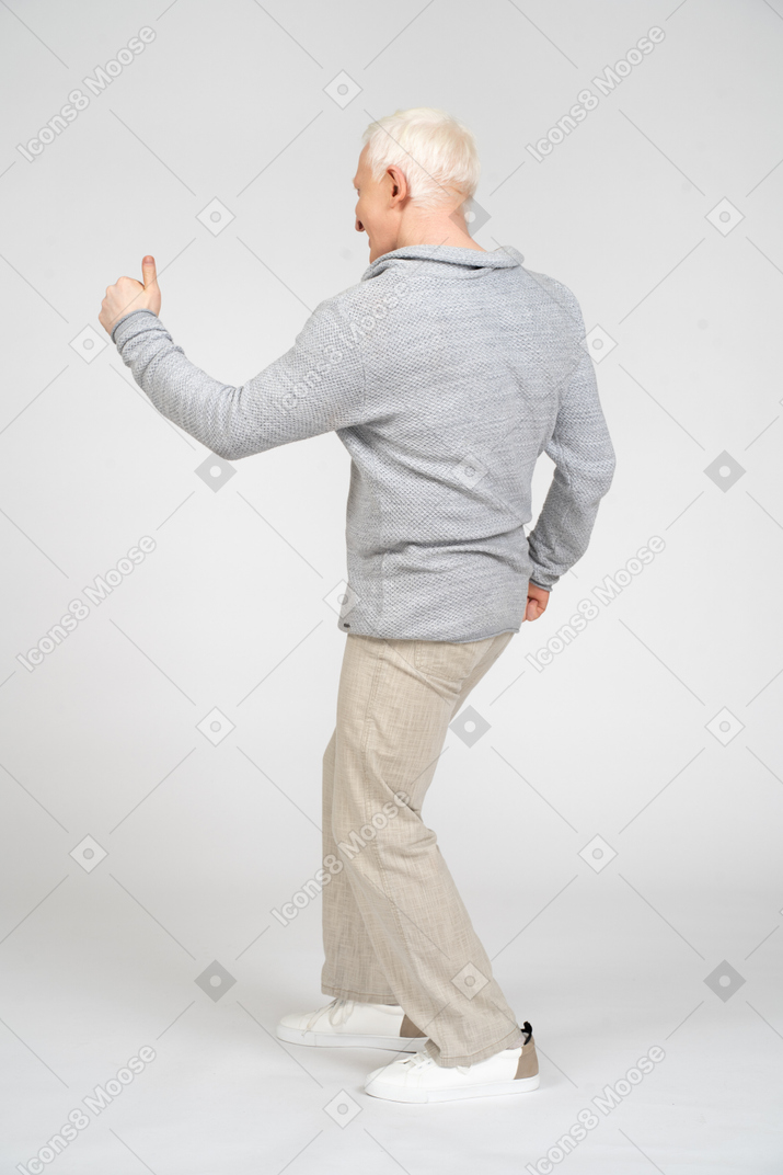 Rear view of man giving thumbs up