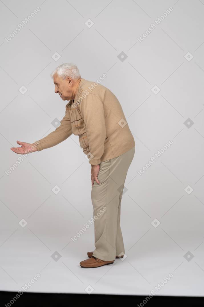 Seitenansicht eines alten mannes in freizeitkleidung, der eine einladende geste macht