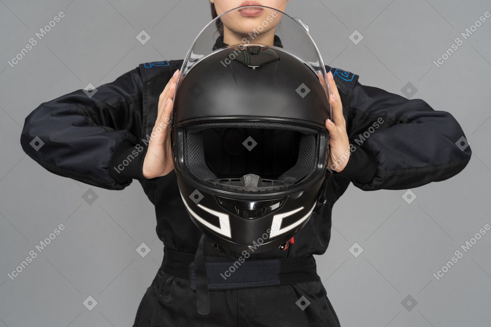 A woman holding a black helmet at a chest level