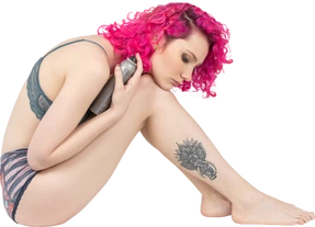 Teenage girl holding a silver bottle and looking at her legs