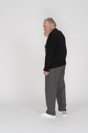Side view of a standing old man looking aside