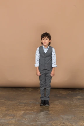 Front view of a boy in suit standing still