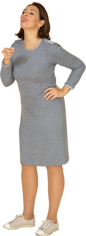 Vista frontale di una donna in abito grigio che indica con un dito