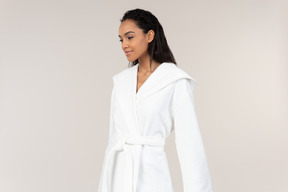 Black woman in white bathrobe going about her morning routine