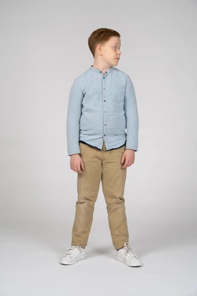 Front view of a cute boy in casual clothes looking aside