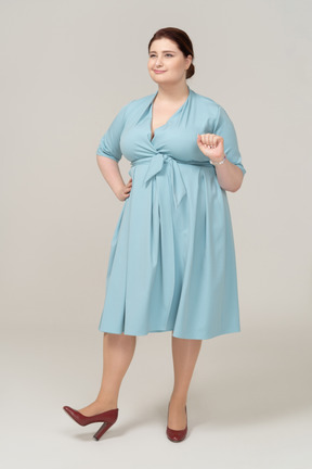 Vista frontal de una mujer feliz en vestido azul gesticulando